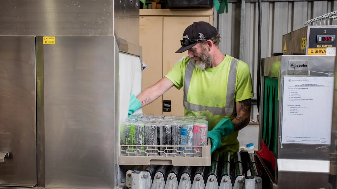 who-we-are A man in coveralls cleans a large window in a stylish, modern home interior.
